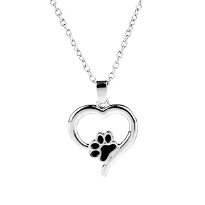 Collana con ciondolo a cuore in argento lucido e impronta di zampa nera su sfondo bianco