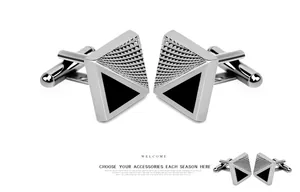 Macro shot of silver square cufflinks with black triangular enamel and ripple texture