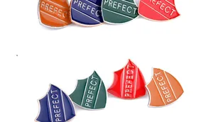 Detail of colorful shield-shaped enamel brooches with white PREFECT lettering text