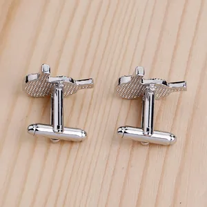 Macro detail of silver ping pong paddle cufflinks with textured rubber surface and toggle back