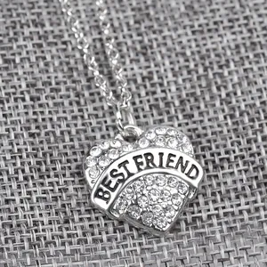 Dettaglio macro della collana a cuore argentata con strass e incisione Best Friend