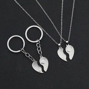 Detail view of silver split heart keychain and necklace set for sisters on black leather