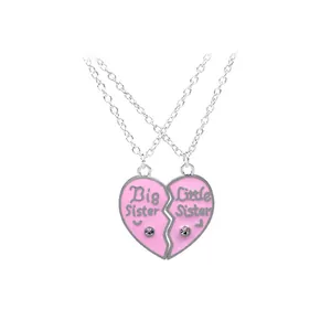 Detail of pink heart-shaped Big and Little Sister necklaces set with crystals