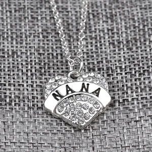 Dettaglio macro del ciondolo a cuore argento con incisione NANA e strass lucidi