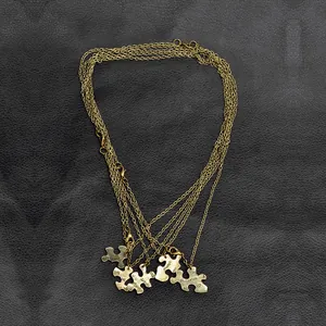 Dettaglio di collane a cuore puzzle da 5 pezzi in oro con messaggi di amicizia incisi