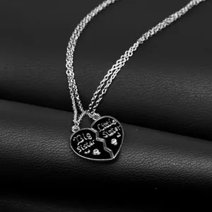 Big and Little Sister heart necklaces with crystals on black leather background