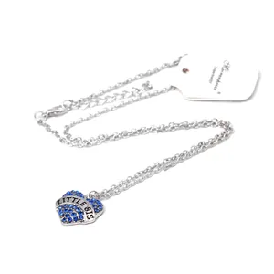 Detailed view of silver heart pendant with blue rhinestones and LITTLE SIS engraving