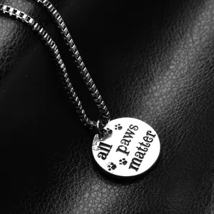 All Paws Matter silver dog tag necklace with engraved paw prints on a box chain