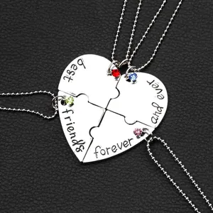Detailansicht der vierteiligen Herz-Puzzle-Kette mit bunten Kristallen und Gravur-Details