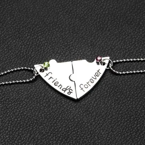 Detail der silbernen Herz-Puzzle-Halskette mit rosa und grünen Strasssteinen für Freunde