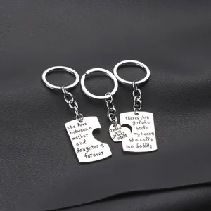Detailed view of silver heart and rectangle puzzle keychains with family engravings