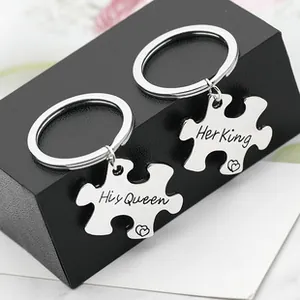 Detail of his queen and her king puzzle piece keychains in polished stainless steel