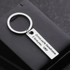 Detail of silver stainless steel keychain with engraved quote on black textured box