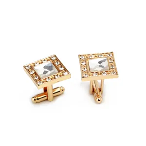 Square gold cufflinks with center zircon crystal and white diamond surround on white background