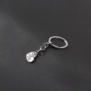 Macro detail of silver heart keychain engraved with Daddy's girl Mama's world text