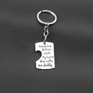 Close-up of puzzle piece metal keychain with Father-Daughter quote on dark background