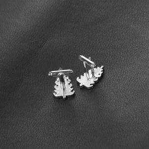 Detail view of silver pine tree cufflinks with toggle closure on black leather