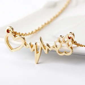 Macro view of gold heart pendant with heartbeat line and cute paw print detail