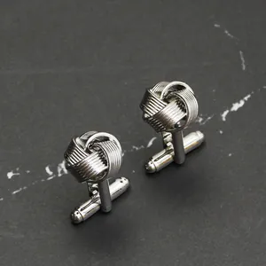 Gros plan de boutons de manchette argentés avec un design de nœud torsadé élégant