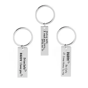 Close-up of three stainless steel keychains with engraved heartfelt messages for dads