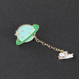 Detail showing mint green planet and sleeping rabbit enamel brooch with gold chain