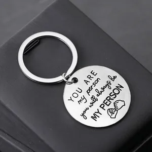 Macro detail of engraved You Are My Person keyring on a textured black gift box