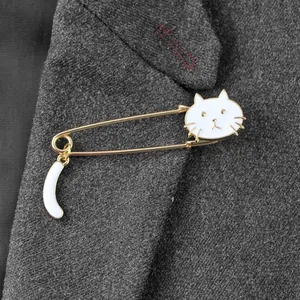 Detailed view of a white enamel cat safety pin brooch on a grey suit lapel jacket