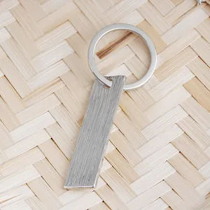Detail of silver rectangular keychain pendant with brushed metal texture finish