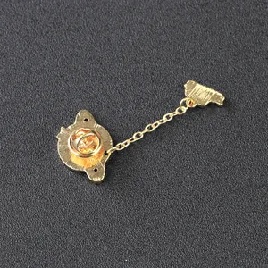 Golden bunny planet brooch set with chain link and butterfly clasp on black background