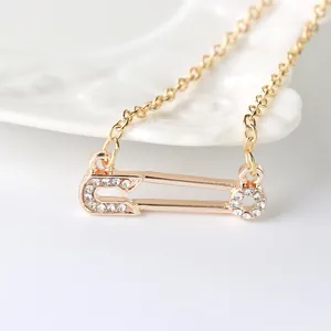 Élégant collier épingle de nourrice doré avec zircons pavés sur une chaîne à maillons