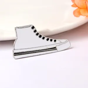 Broche en émail basket montante blanche avec contour en métal argenté sur fond blanc