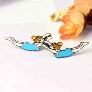 Close-up of enamel diving girl brooches with blue swimsuits on a clean background