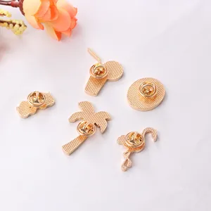 Detail view of gold-plated metal enamel brooch backs with secure butterfly clutch pins