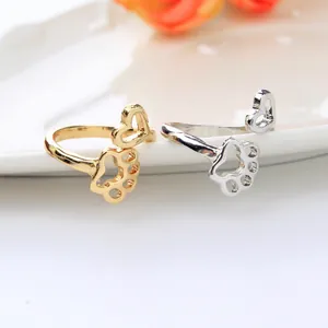Dettaglio di anelli oro e argento con motivi a cuore e impronta di zampa traforati