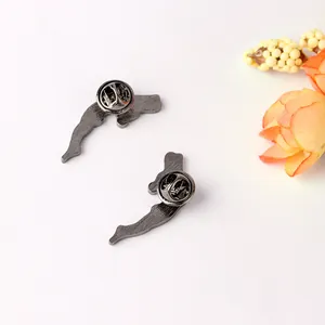Detail view of the metal butterfly clasp backings on the dolphin-shaped brooches