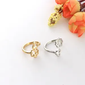 Dettaglio del design a cuore e zampa di cane traforata su anelli in oro e argento