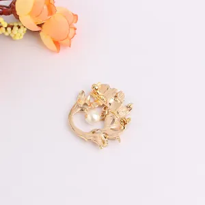 Detailed back view of gold hollow leaf brooch with pearl and metal pin safety clasp
