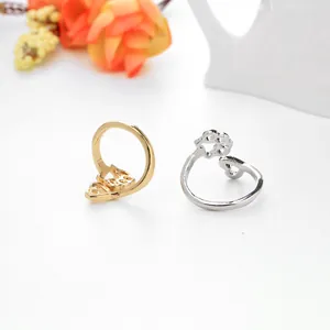 Anelli minimalisti in oro e argento con motivi a zampa di cane traforati su fondo bianco