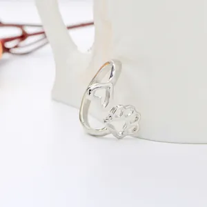 Dettaglio anello aperto in argento con motivi a cuore e zampa di gatto traforati