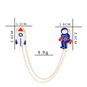 Vue détaillée des épingles de col astronaute et fusée avec chaînes dorées et tailles