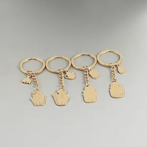 Detail of four golden zinc alloy keychains with garden tools and succulent charms