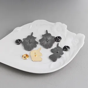 Detail view of gold and gunmetal enamel pin backs with butterfly clutches on a tray