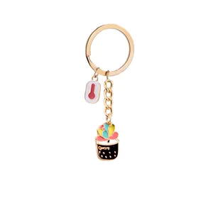 Detail of gold metal keychain with rainbow succulent plant and white thermometer charm