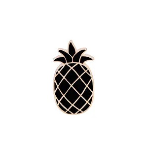 Dettaglio di una spilla smaltata a forma di ananas con riempimento nero e linee dorate