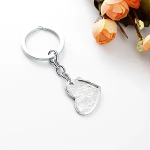 Detailed back view of heart pendant keychain with a brushed metal texture and ring