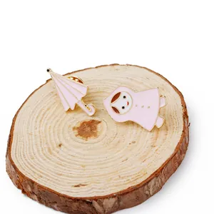 Détail de broches en émail rose avec une fille et un parapluie sur bois