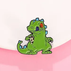 Detail of green Reptar enamel pin holding a pepperoni pizza slice on pink background