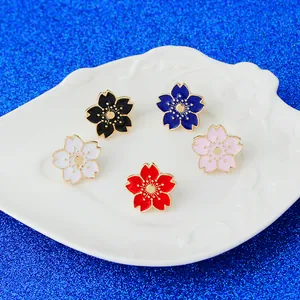 Lot de cinq broches en émail fleurs de cerisier aux couleurs variées et bordures dorées