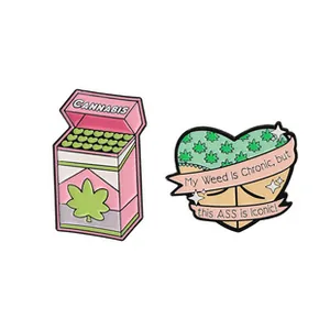 Detail of pink cannabis box and heart-shaped enamel pins with iconic slogan