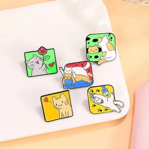 Macro shot of five creative cat enamel pins with floral designs on a white tray